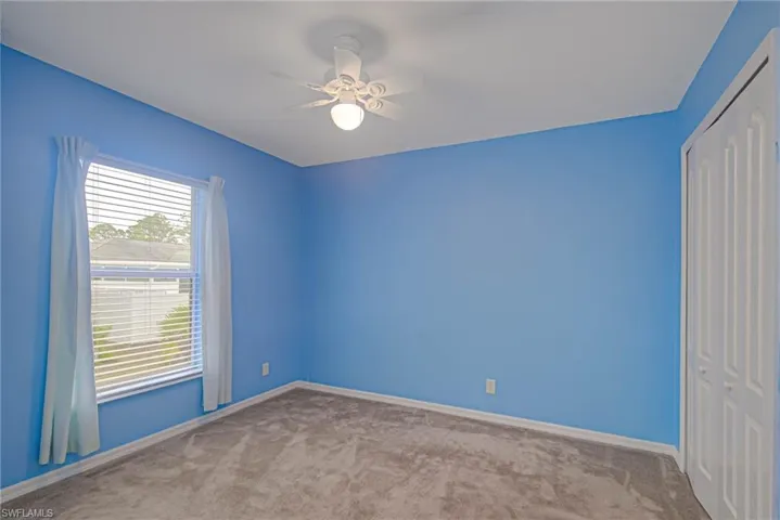 Spare room featuring light carpet and ceiling fan