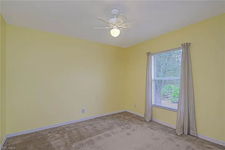 Spare room featuring ceiling fan and light carpet
