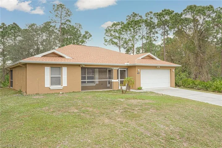 Ranch-style house featuring a garage and a front lawn