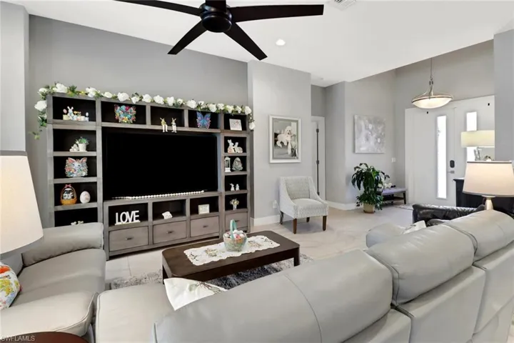 Living area with baseboards, ceiling fan, visible vents, and light tile patterned floors