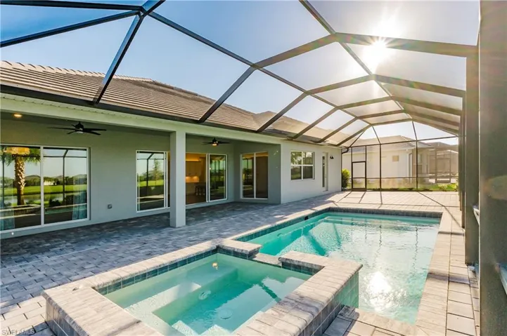 View of pool with a sunroom, a patio, a pool with connected hot tub, and a lanai