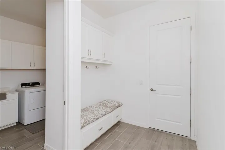 Mudroom with wood finish floors and washer / dryer