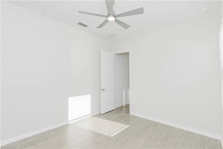 Unfurnished room with wood finish floors and ceiling fan