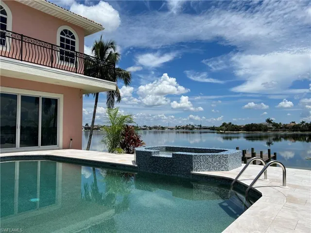 View of pool featuring an in ground hot tub and a lake view
