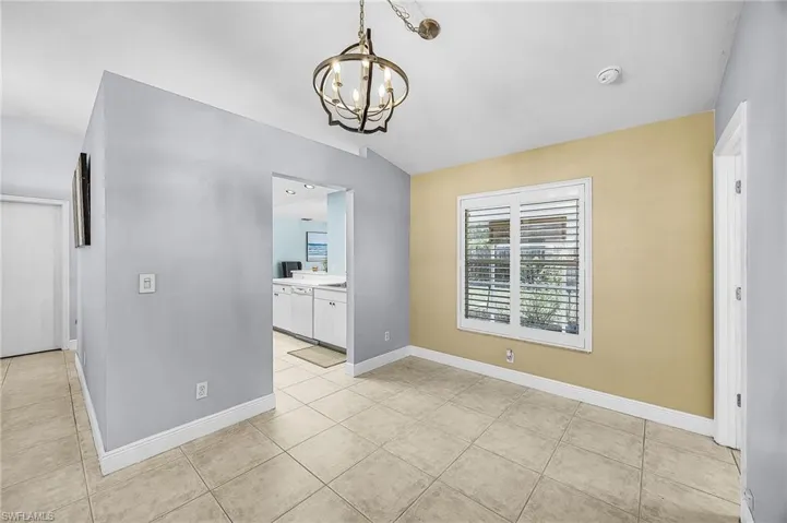 Unfurnished dining area with a chandelier and light tile patterned floors
