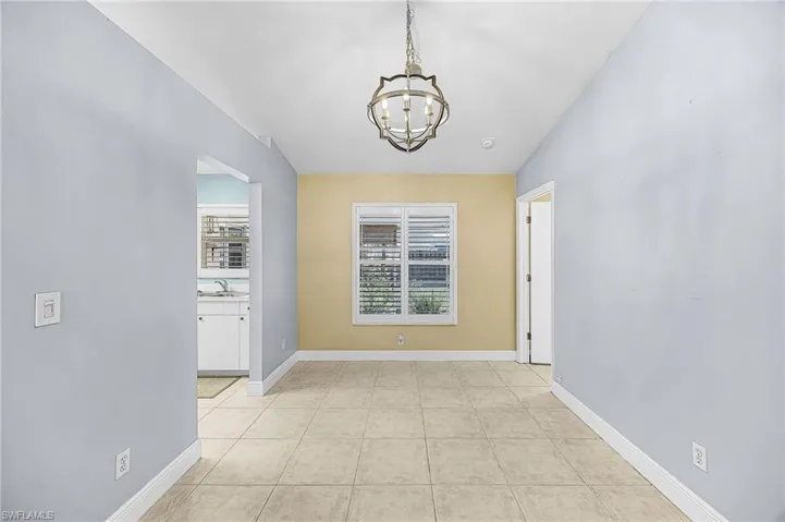 Spare room featuring a chandelier and light tile patterned floors