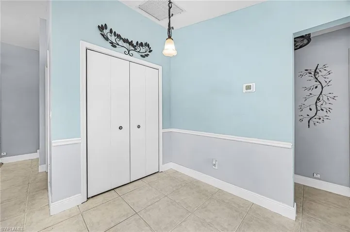 Unfurnished dining area featuring light tile patterned flooring and baseboards