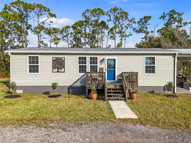 Manufactured / mobile home with a front yard and a wooden deck