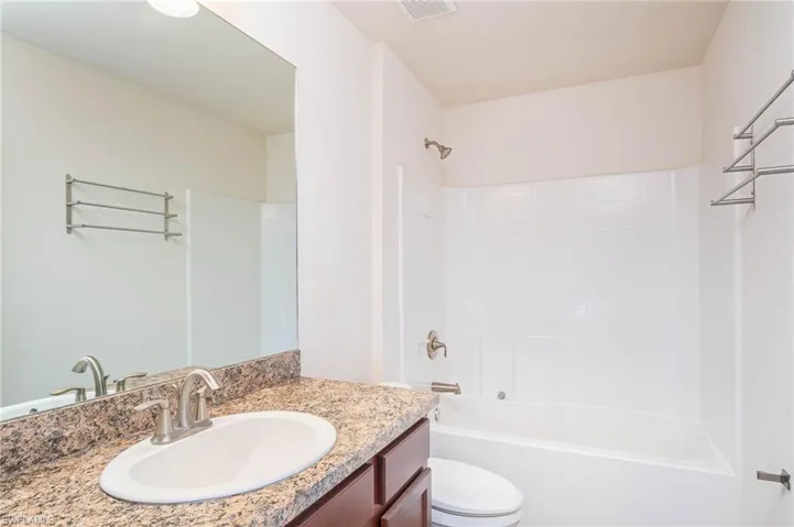 Full bath with toilet, visible vents, shower / tub combination, and vanity