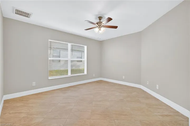 Spare room featuring a ceiling fan and light tile patterned floors