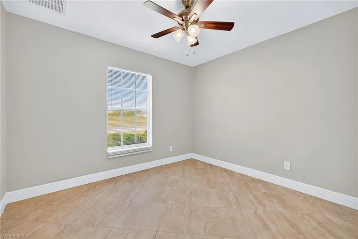 Spare room featuring ceiling fan and light tile patterned floors