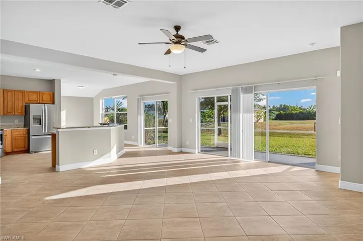 Unfurnished living room featuring light tile patterned floors and ceiling fan