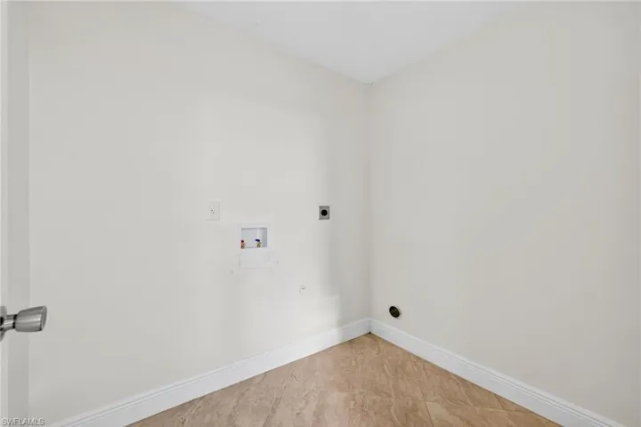 Laundry area featuring hookup for an electric dryer, hookup for a washing machine, and tile patterned floors