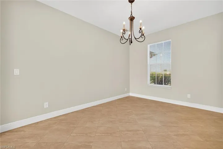 Spare room featuring a chandelier and light tile patterned floors