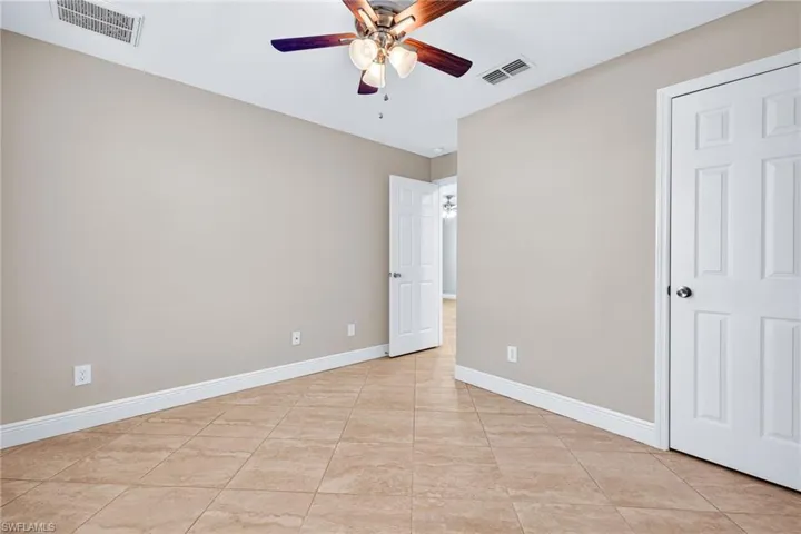 Unfurnished bedroom featuring ceiling fan and light tile patterned floors