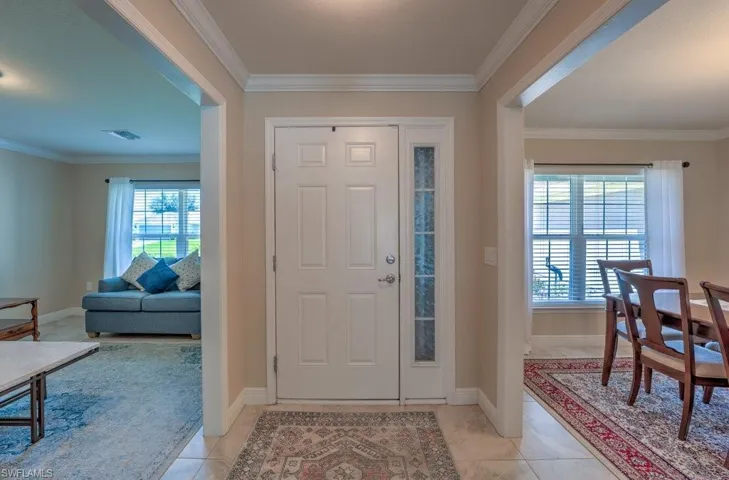Tiled entrance foyer featuring crown molding