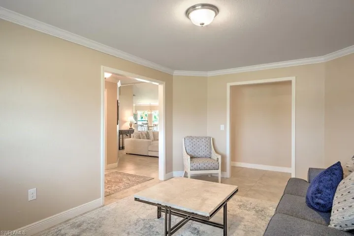 Living room featuring light tile patterned flooring and ornamental molding