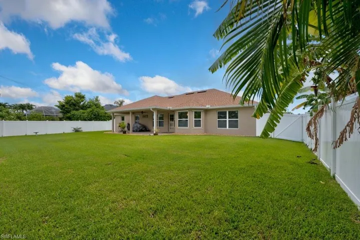 Rear view of property with a lawn