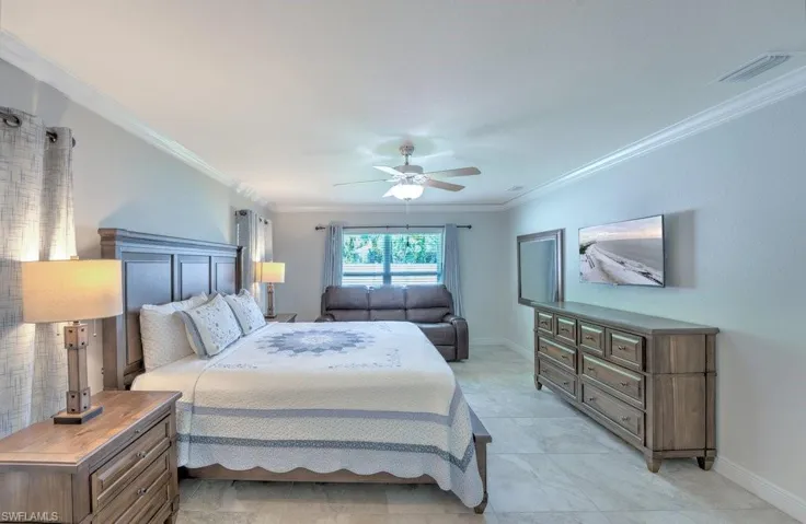 Bedroom featuring ceiling fan, ornamental molding, and light tile patterned floors