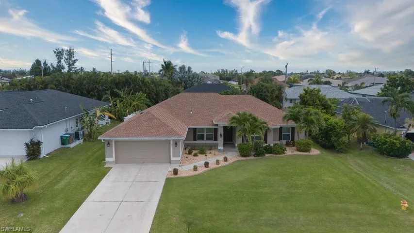 View of front facade featuring a garage and a front yard