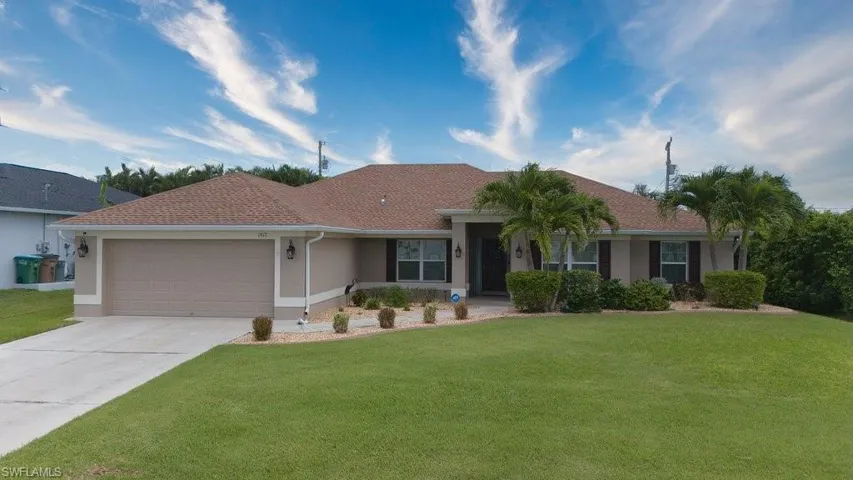 Ranch-style house featuring a front yard and a garage