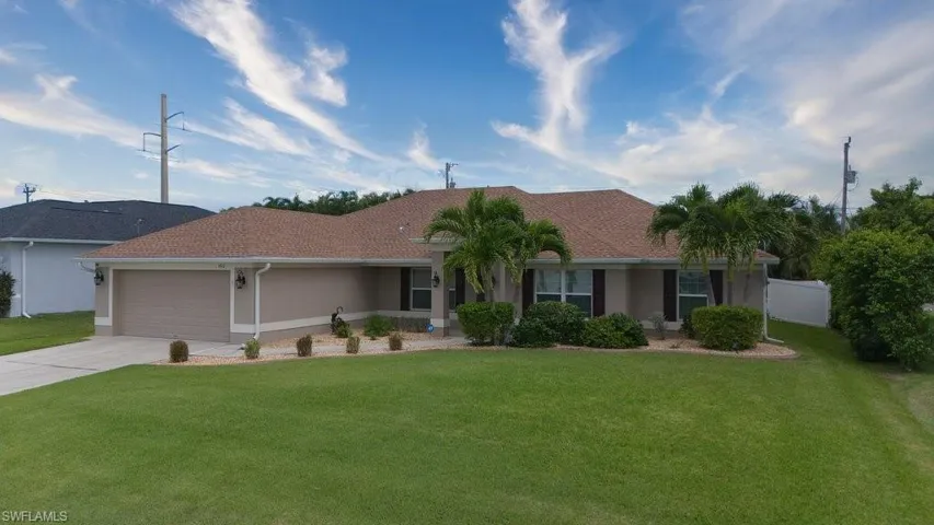 Ranch-style home featuring a front yard and a garage