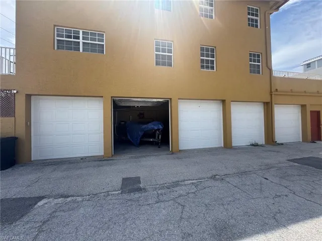 Four individual garage bays with white panel doors. Garage #2 comes with the sale.