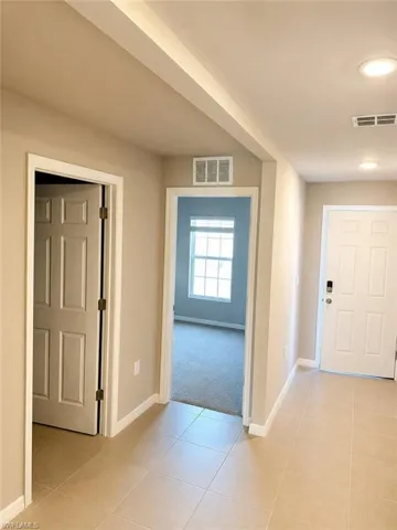 Neutral tone wall paint, recessed lighting, tile flooring, and paneled interior doors