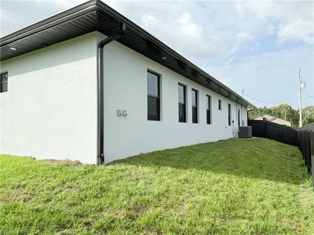View of side of property featuring stucco siding and cooling unit