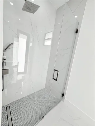 Full bathroom with a marble finish shower, marble tiled floors, and recessed lighting