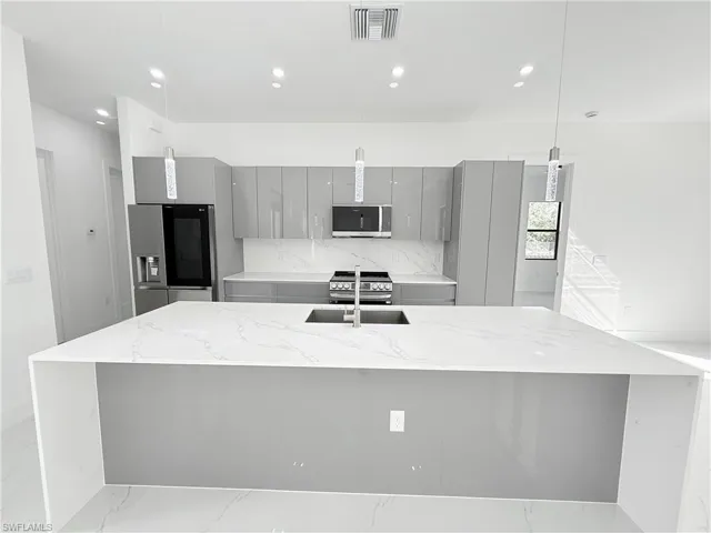 Kitchen featuring gray cabinetry, appliances with stainless steel finishes, modern cabinets, and recessed lighting