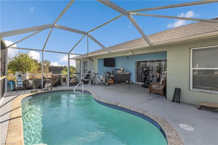 Outdoor pool featuring a lanai, a sunroom, and a patio area