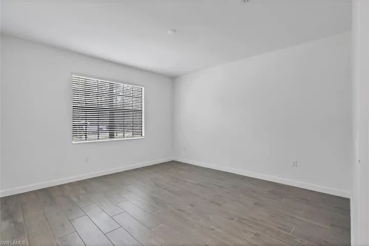 Empty room featuring baseboards and light wood-type flooring