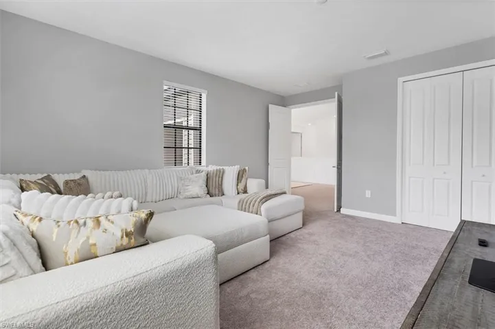 Carpeted living area with baseboards