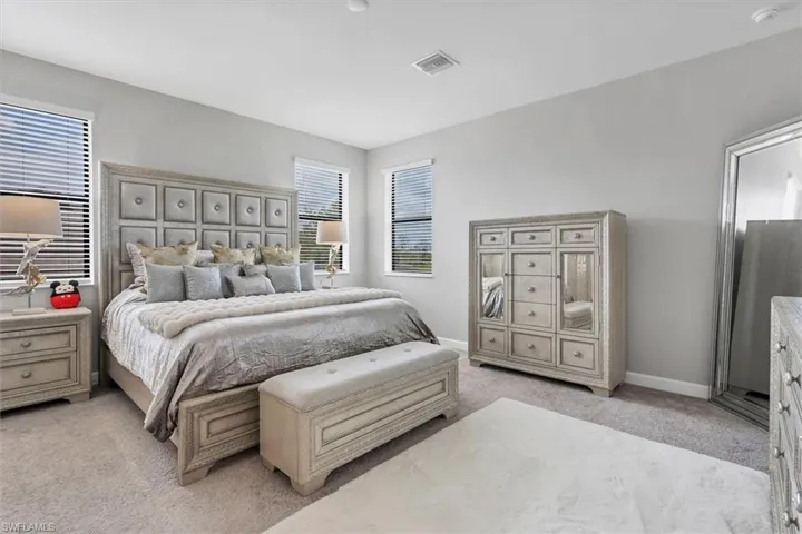 Bedroom featuring light colored carpet and baseboards