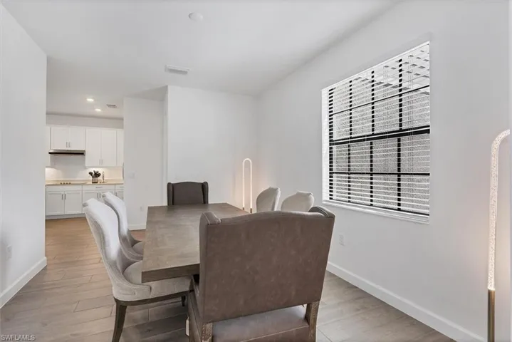Dining area with light wood-style flooring and recessed lighting