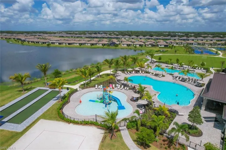 Aerial perspective of suburban area featuring a pool and a nearby body of water