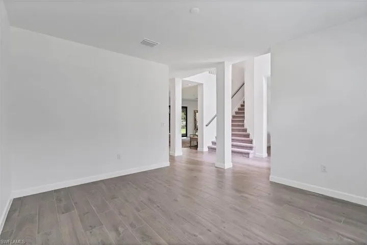 Unfurnished room featuring stairway and light wood-type flooring