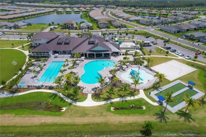 Aerial view of residential area featuring a pool and a large body of water