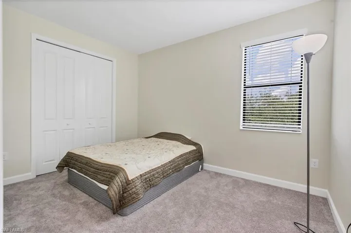 Carpeted bedroom with baseboards and a closet