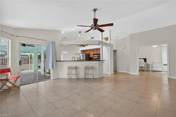 Living Room with view of the Kitchen, Den and side entrance to the Pool area
