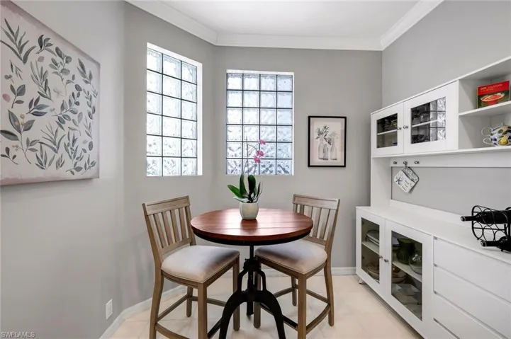 Dining room featuring light tile patterned floors and ornamental molding