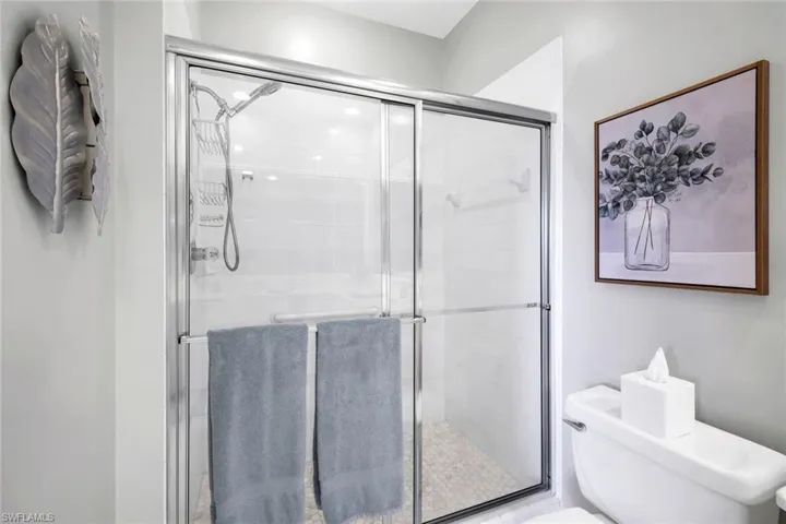 Bathroom with a shower with shower door and toilet