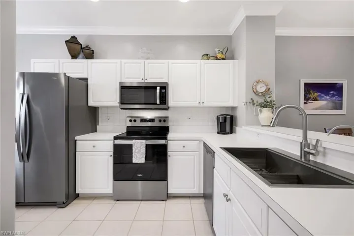 Kitchen with white cabinetry, sink, and stainless steel appliances