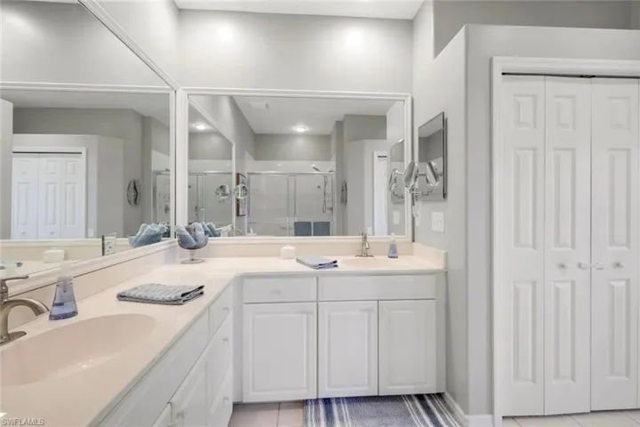 Bathroom featuring tile patterned floors, vanity, and an enclosed shower