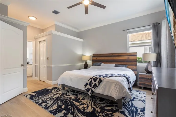 Bedroom featuring ceiling fan, crown molding, and light hardwood / wood-style floors
