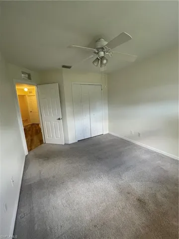 Unfurnished bedroom featuring carpet flooring, a closet, and ceiling fan