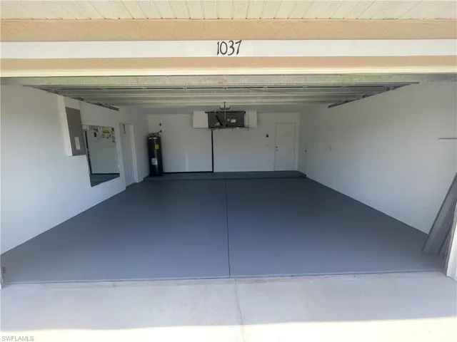Garage featuring electric panel and electric water heater