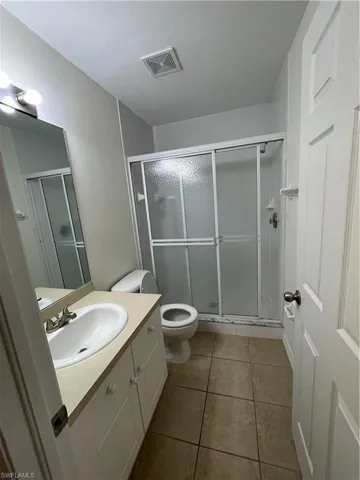 Bathroom with vanity, a stall shower, and light tile patterned flooring
