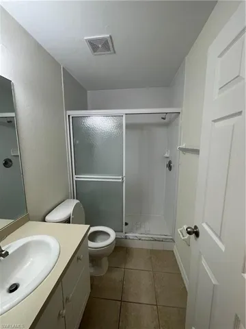Full bathroom featuring vanity, a shower stall, and light tile patterned floors